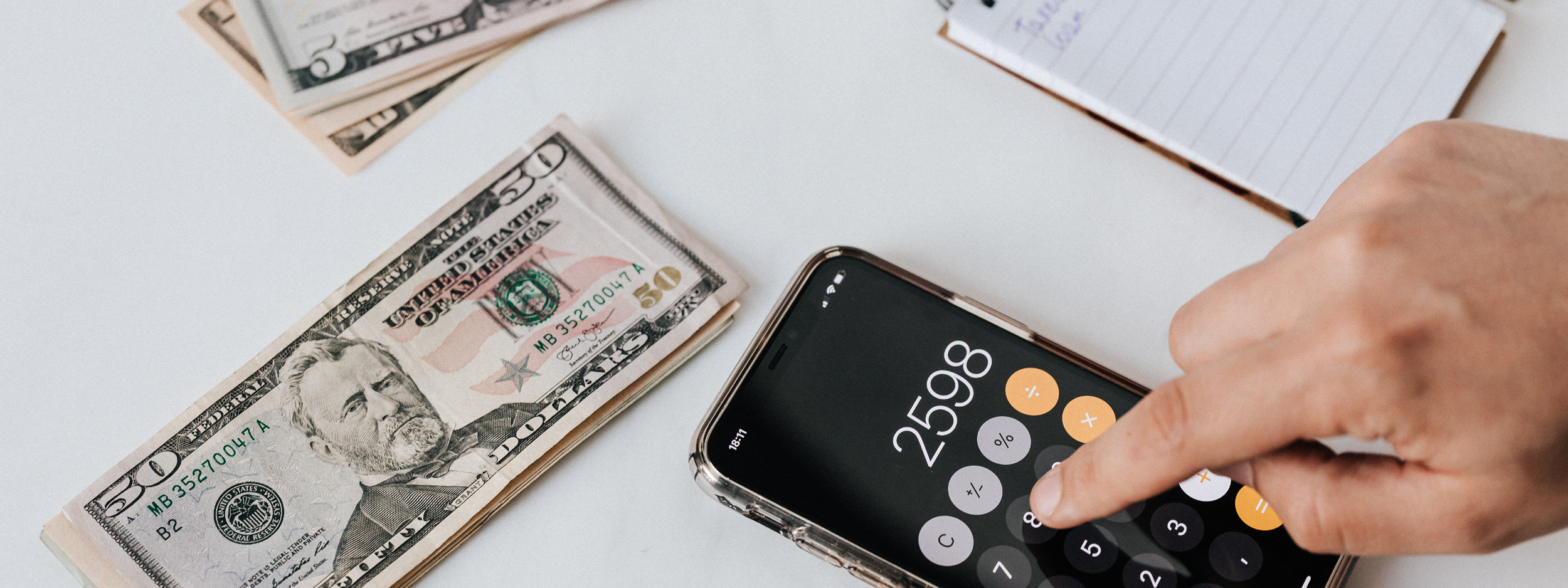 Cash, notepad and calculator on table