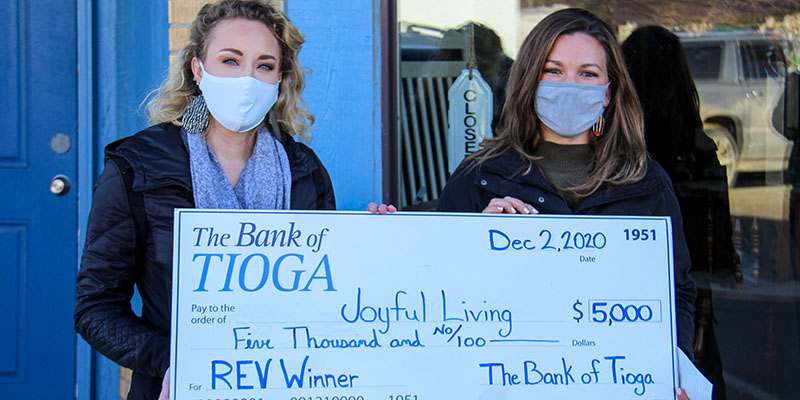 Joyful Living accepting their REV winnings check