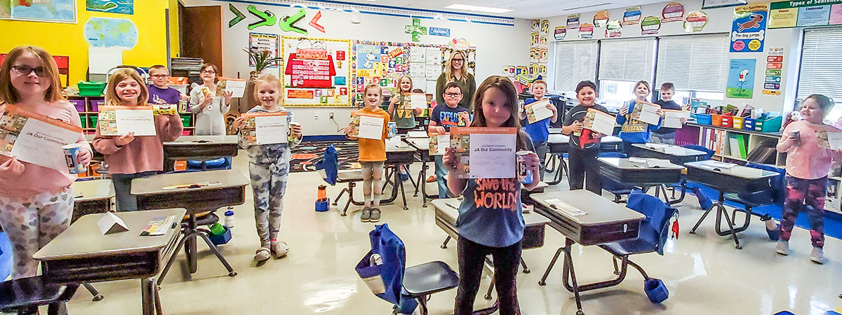 students holding their junior achievement certificates 