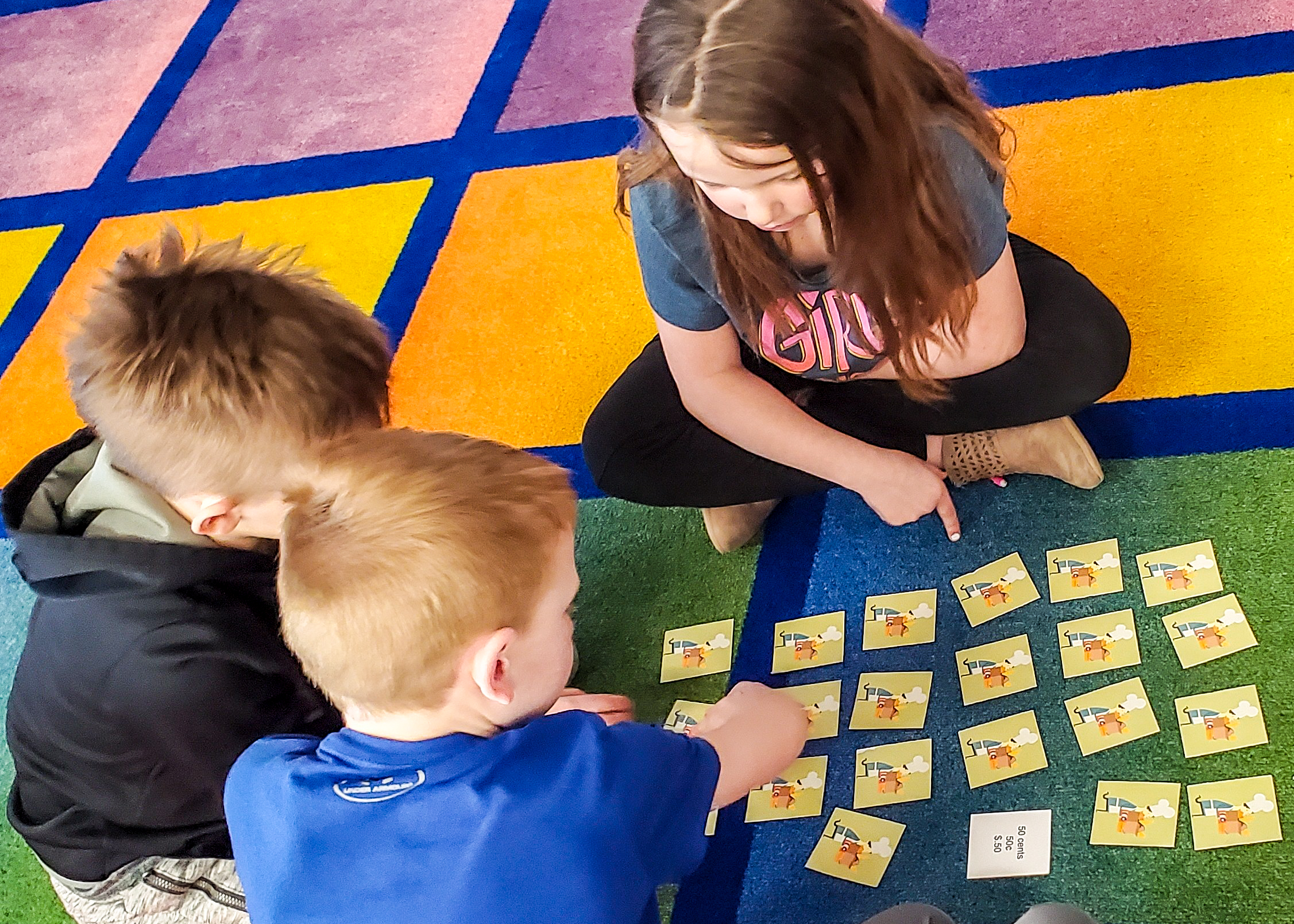 junior achievement students playing a game on a rug