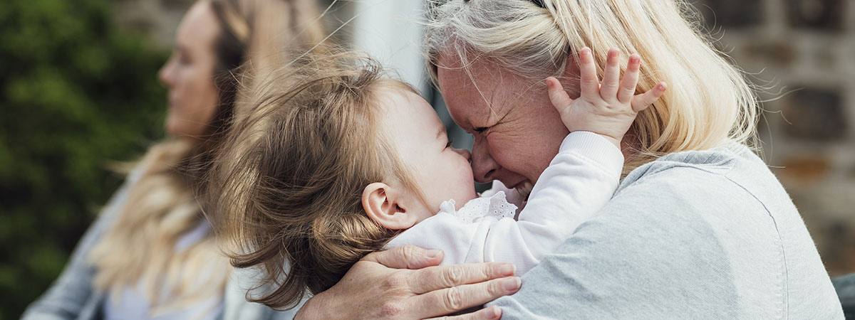 grandmother hugging her grandaughter smiling