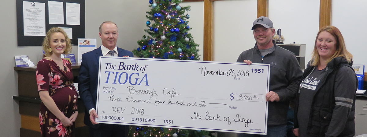 employees and recipients pose with large check