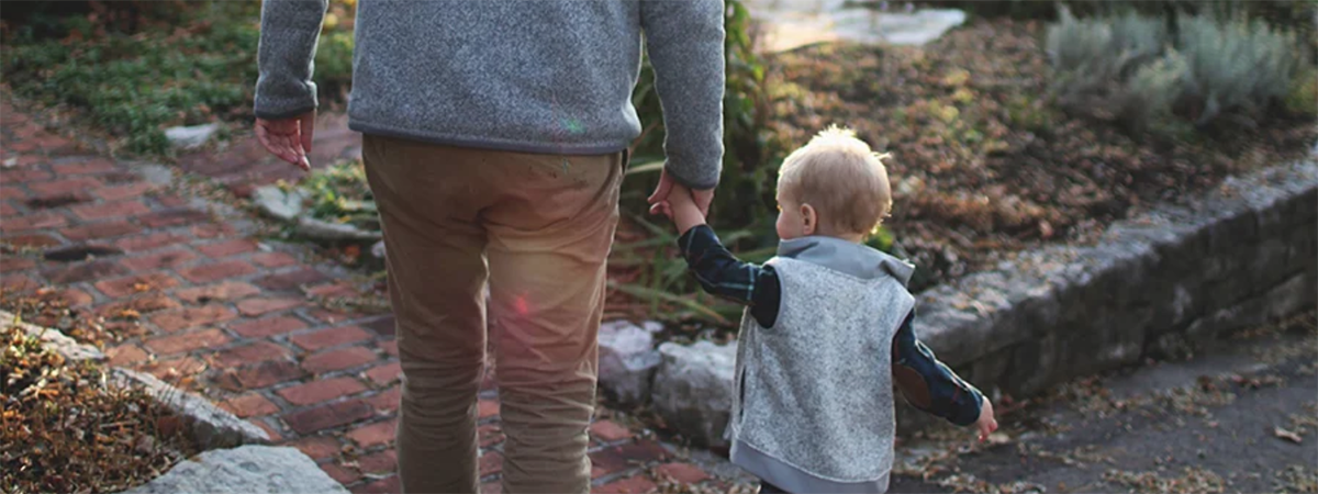 dad and son holding hands while walking