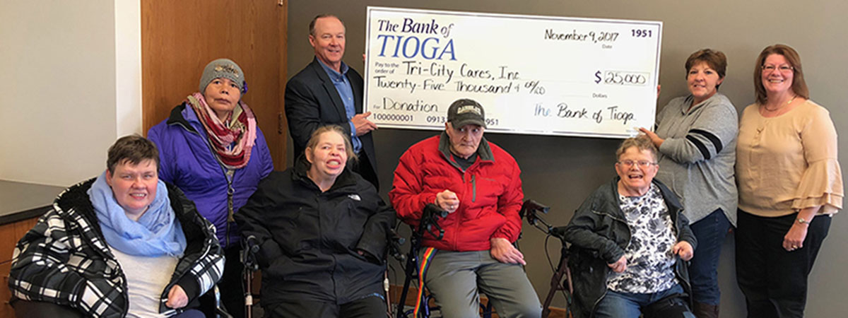 employees and residents hold large check